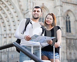 Young tourists with map walking with baggage