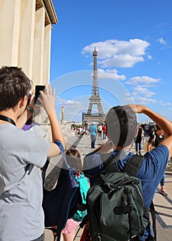 Young tourists photograph the Eiffel Tower