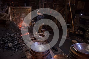 Young traditional Blacksmith working with open fire