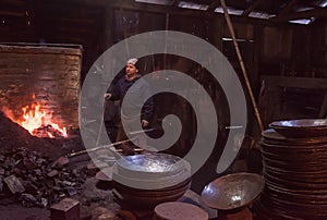 Young traditional Blacksmith working with open fire