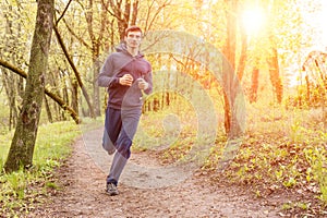 Young trail runner man jogging in the morning park