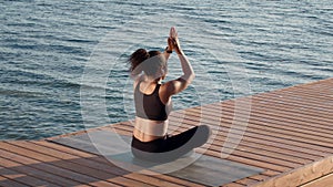 Young tranquil african american woman athlete meditating outdoors, sitting in lotus position on pier, free space