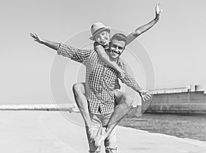 Young travel couple having fun at sea harbour before going in summer vacation - Happy tourists laughing and smiling duing holiday