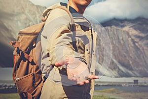 Young travel man lending a helping hand in outdoor mountain scenery