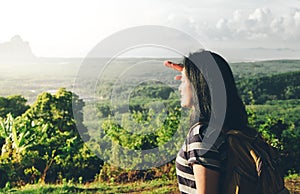 young traveler backpacker looking forward at sun to see landscape view of mountain at sunrise