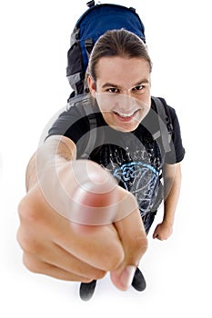 Young traveler with bag pack pointing at camera