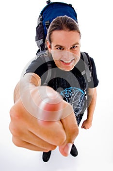 Young traveler with bag pack pointing at camera