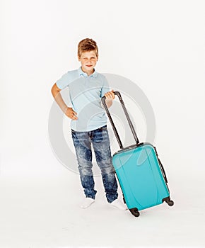 The young traveler boy with a suitcase. Isolated over white background