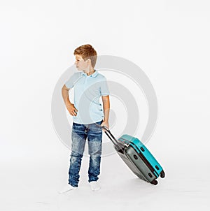The young traveler boy with a suitcase. Isolated over white background