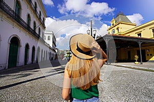 Young traveler girl walking between the palace of Pele Museum and the historic tram station, touristic