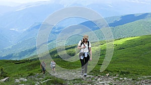 Young traveler hiking girl with backpacks. Hiking in mountains. Concept of travelling, hiking, nature.