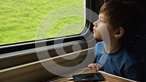 Young traveler looking through train window