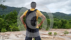 Young traveler man with backpack standing relax against landscape scenery mountain peak in phuket thailand