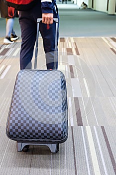 Young traveler man dragging luggage at airport