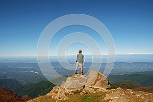 Young traveler standing on top of mountain with cliff