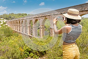 Young traveler taking selfie with roman Aqueduct Pont del Diable near Tarragona