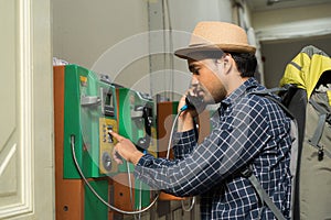 Young traveler using  public payphone