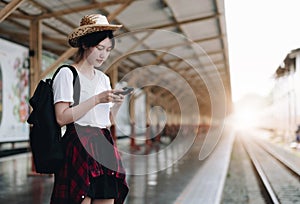 Young traveler woman looking for friend planning trip at train station. Summer and travel lifestyle concept