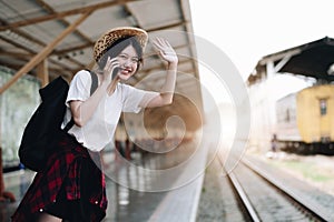 Young traveler woman looking for friend planning trip at train station. Summer and travel lifestyle concept