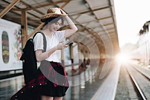 Young traveler woman looking for friend planning trip at train station. Summer and travel lifestyle concept