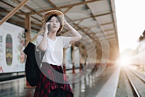 Young traveler woman looking for friend planning trip at train station. Summer and travel lifestyle concept