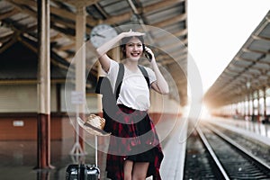 Young traveler woman looking for friend planning trip at train station. Summer and travel lifestyle concept