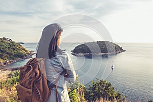 Young traveler woman standing and looking at view enjoying a beautiful of nature at top of mountain and sea