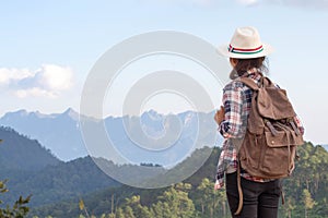 Young traveler woman with stylish backpack looking forward at amazing mountains view. Enjoying nature, relax, pleasure