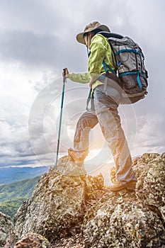 Young traveler woman with stylish backpack  looking forward at amazing mountains view. Enjoying nature, relax, pleasure