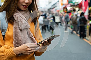 Young traveler women using smart phone to searching the map at the street market, close up