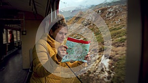 Young traveling woman look at map on train trip