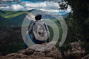 Young traveling woman on the top of the mountain cliff