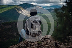 Young traveling woman on the top of the mountain cliff