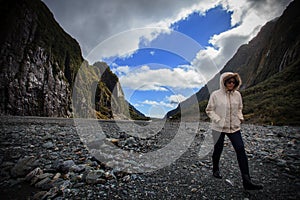 Young traveling woman walking in franz josef glacier trail important traveling destination in south island new zealand