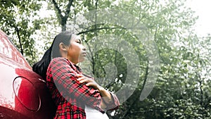 Young traveller woman standing outside car and enjoying with nature in natural park. Travel by car. Concept of transport and