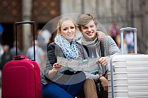 Young travellers with city map at street