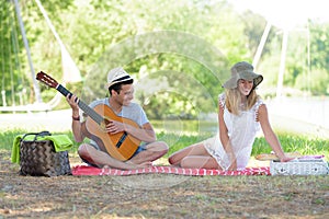 Young travellers man and woman playing guitar