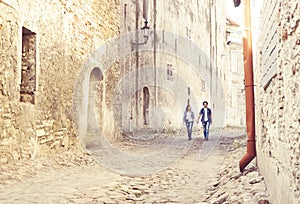 Young travelling couple having a medieval walk on an old street