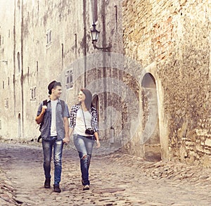 Young travelling couple having a medieval walk on an old street