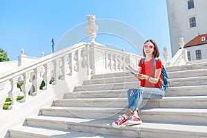 Cestujúca žena sediaca s mapou na krásnych mramorových schodoch v starom európskom meste