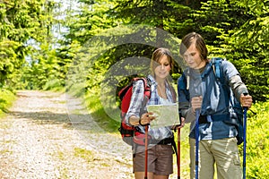 Young trekking couple checking the map