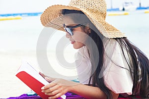 Young trendy cool hipster woman reading a book and lying in the
