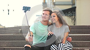 Young trendy couple taking selfie outdoors.
