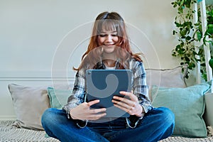 Young trendy girl using digital tablet for studying communication leisure