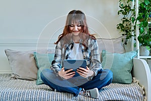 Young trendy girl using digital tablet for studying communication leisure