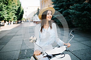 Young woman drinking takeaway coffee near her moped in the morning