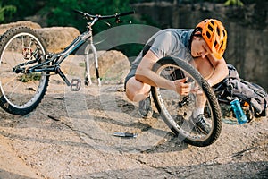 young trial biker fixing bike