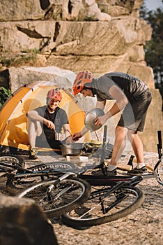 young trial bikers cooking food