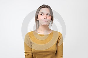 Young tricky woman having something in mind with sly facial expression