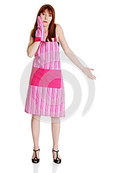 Young troubled housewife in pink apron